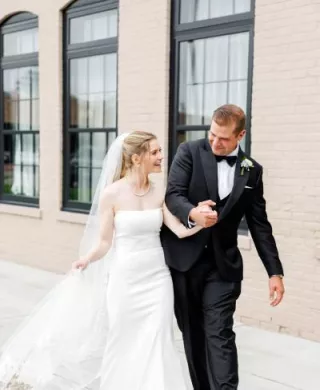 Colette and Dylan walk outside of The Confluence Hotel on their wedding day