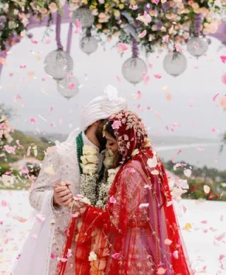 Bride and groom embrace under lush mandap at Malibu Seaview Estate