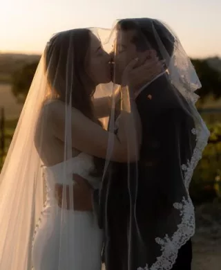 Bride and groom share a kiss on the grounds of Hearst Ranch Winery during golden hour
