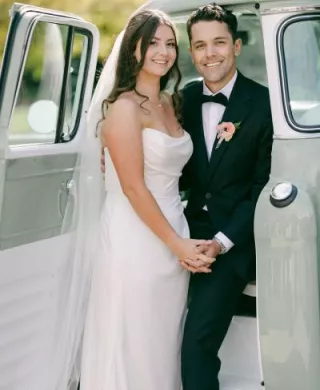 Bride and groom pose next to retro truck in wedding day at Cavalli Estates