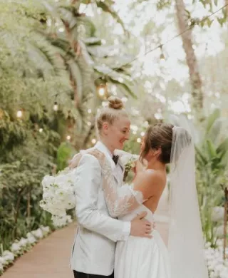 Taylor and Summer embrace on the grounds of Botanica on their wedding day