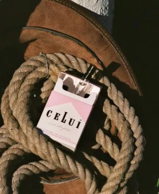 Celui promotional photo with fragrance pack sitting in a bundle of rope