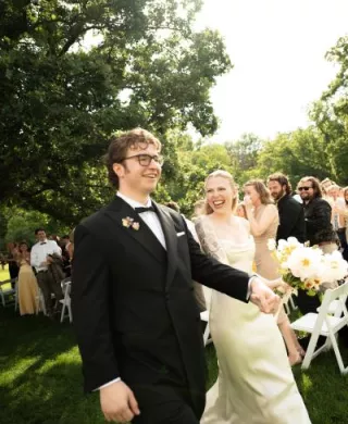 Addie and Walker beam as they walk down the aisle after exchanging I do's at Mayowood Stone Barn