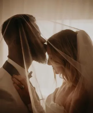 Groom kiss bride's forehead in close up shot in private wedding portrait session