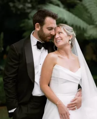 Sophie and Andrew pose side by side in their wedding attire