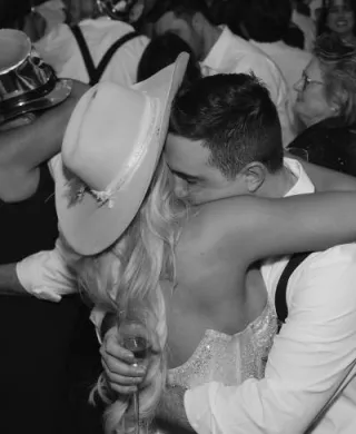 Bride and groom embrace in a hug, depicted in black and white