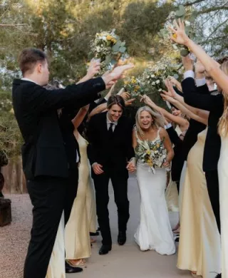Bride and Groom run under archway created by bridal party