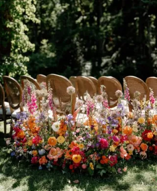 Bold abundance of blooms line the outdoor aisle in wedding day at Fox Hollow Farms