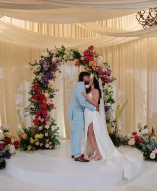Danielle and Brandon share a kiss at the indoor floral altar