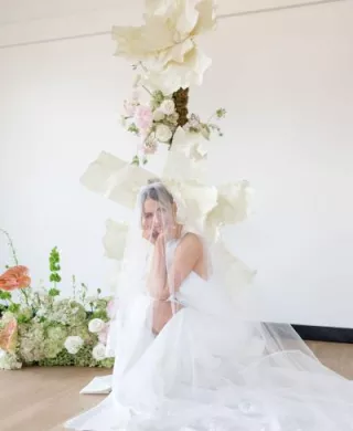 Model poses in front of hand crafted floral vignette 