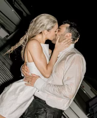 Bride and groom share a kiss after jumping in Lake Geneva in their wedding attire