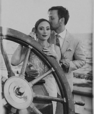 Kelsey and Gawan pose at the helm of Schooner Zodiac on their wedding day