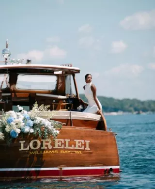 Model poses on a boat decorated in florals floating on Lake Geneva outside of The Abbey Resort