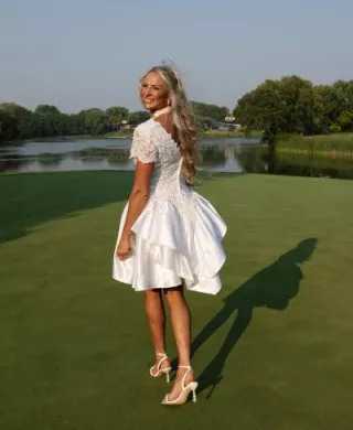 Bride walking on golf course in her mother's reworked bridal gown