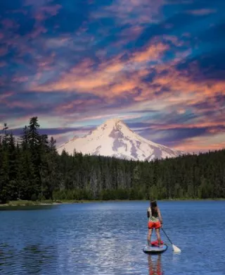 Paddle boarder on a lake with mountain in the background