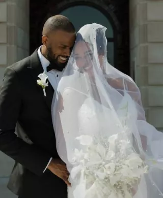 Bride and groom stand close together in an embrace on their wedding day