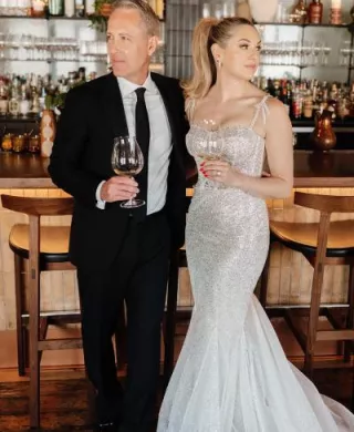 Kate and Tim pose with cocktails at the bar during their reception at Mara