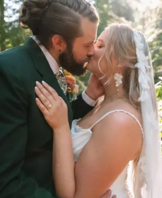 Natasha and Will share a kiss on their wooded wedding day