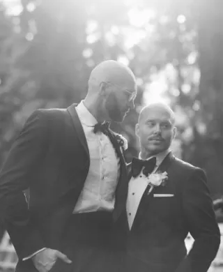 Zach and Bryce pose in their ceremony attire, in black and white