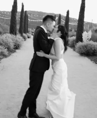 Stephanie and David Share a Kiss Outdoors at Wedding at Tre Posti