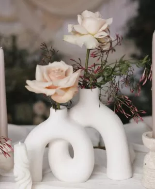 Sculptural stone vase holding two roses in imagined reception design