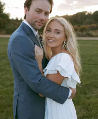 Bride and groom smile and embrace on the grounds of Rustic Roots Winery