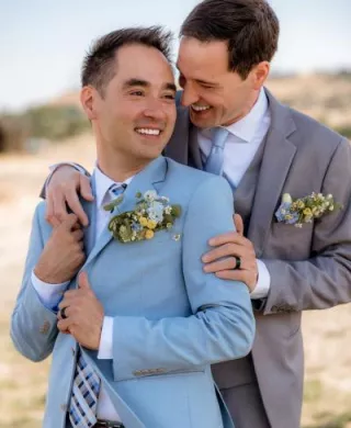 Jonathan and Robbie pose in a warm embrace on their wedding day