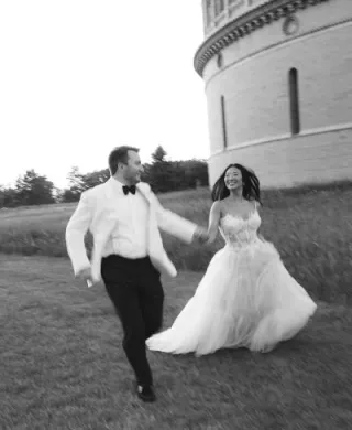 Bride and groom frolick through the grounds outside of Yerkes Observatory hand in hand on their wedding day