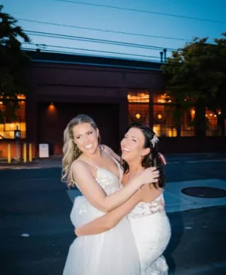 Brides share an embrace outside of their wedding day at The Ruins