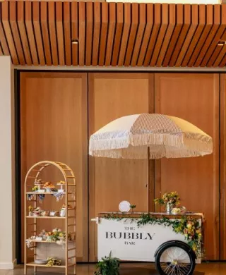 Spread of pastries and small bites next to a bubbly bar cart for spakrling wine