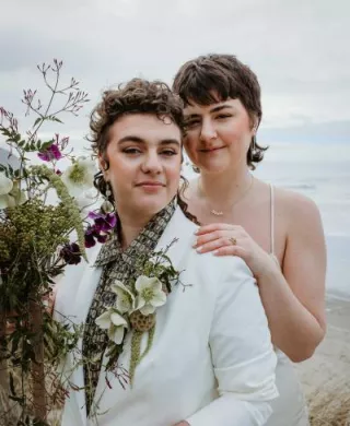 Close up of couple posing, one standing behind the other, in intimate elopement on Cannon Beach