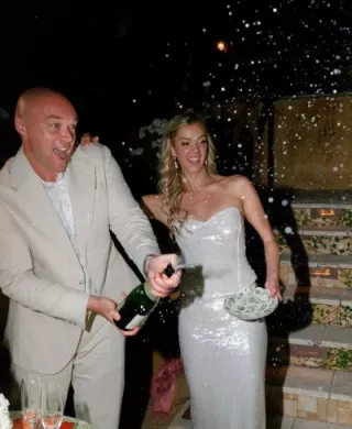 Bride and groom pop champagne at reception at groom's private residence