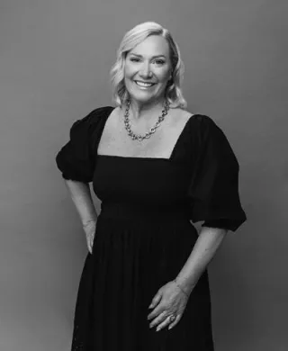 Headshot of Editor Lara Burnap smiling, in black and white