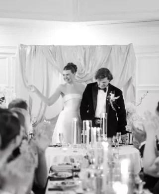 Natalie and Trip laughing at the head table of their reception at St. Paul College Club 