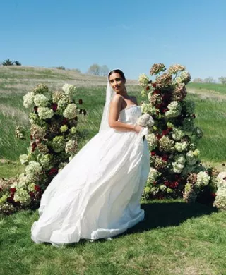 Model poses in front of enchanting altar comprised of monochromatic florals on the expansive grounds of Selmer + Stone