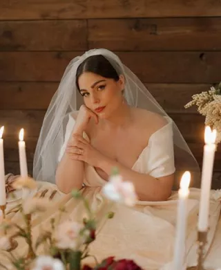 Model poses sat at staged reception table at Abbey Road Farms