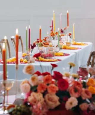 Vibrant tablescape featuring juicy hued florals, fruit accents and taper candles at Woodhaven
