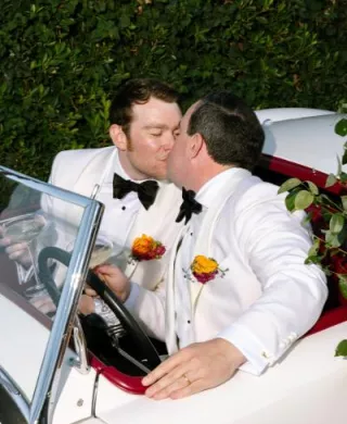 James and Timmy share a kiss in their floral decorated vintage getaway car