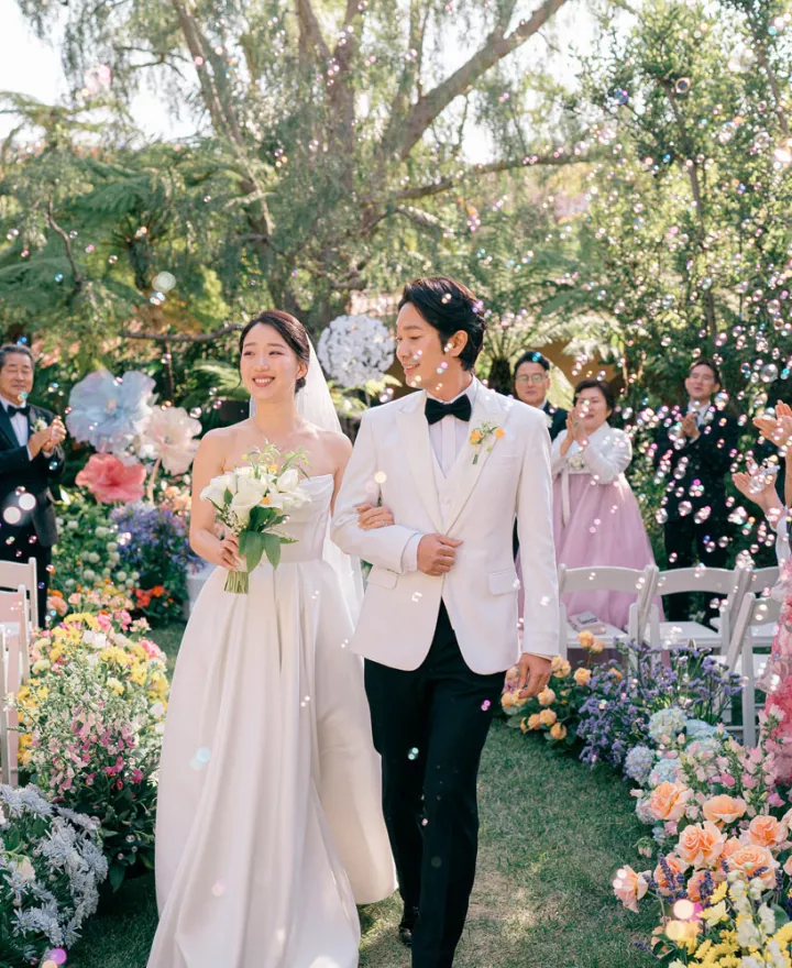Bright flowers at the couple's outdoor ceremony set a stunning contrast to the darker, classical hues at the reception.