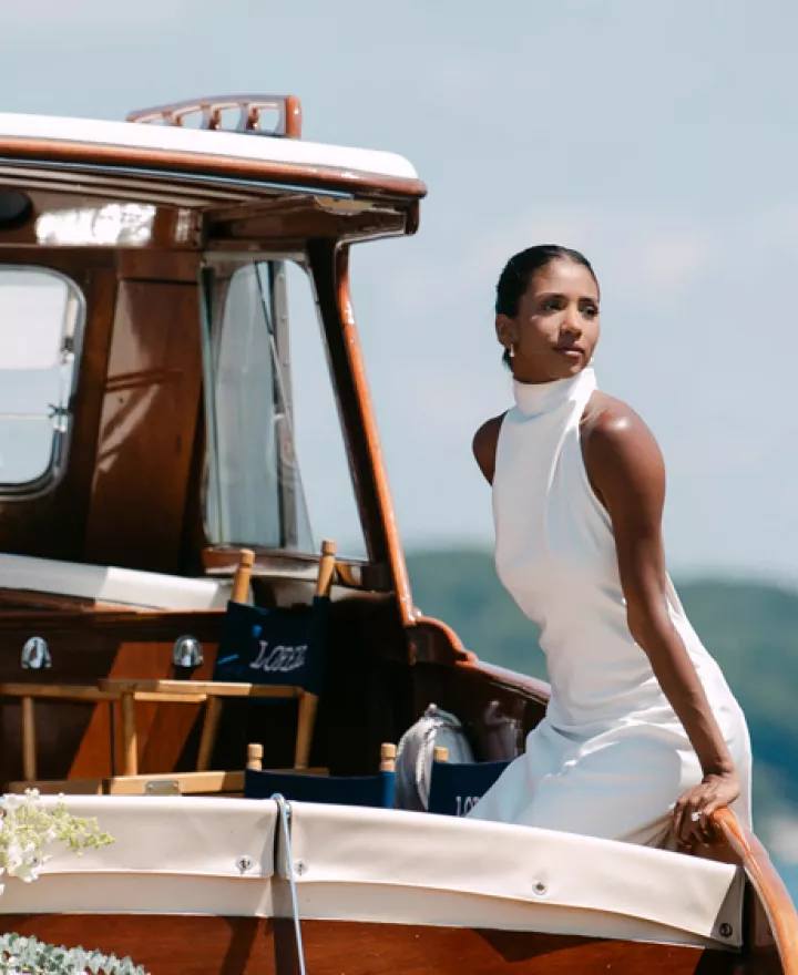 Model poses on a boat decorated in florals floating on Lake Geneva outside of The Abbey Resort