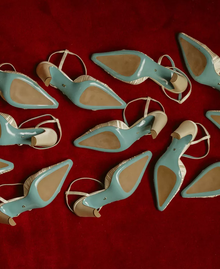 Six pairs of Valentina Rangoni designed shoes, soles up on a red carpet 