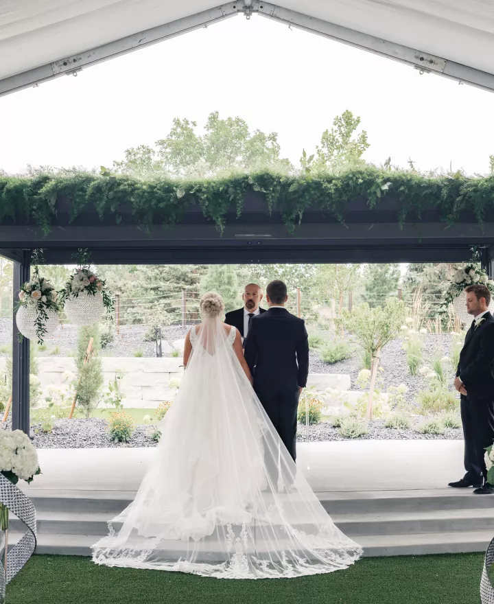 Bride and groom stand with backs facing the ceremony while standing at rectangular altar at Venue 5 Twenty-Two