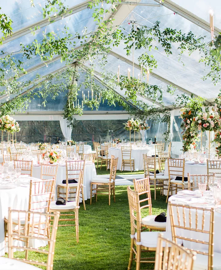 Tented reception space featuring greenery and lush florals at Tumble Creek