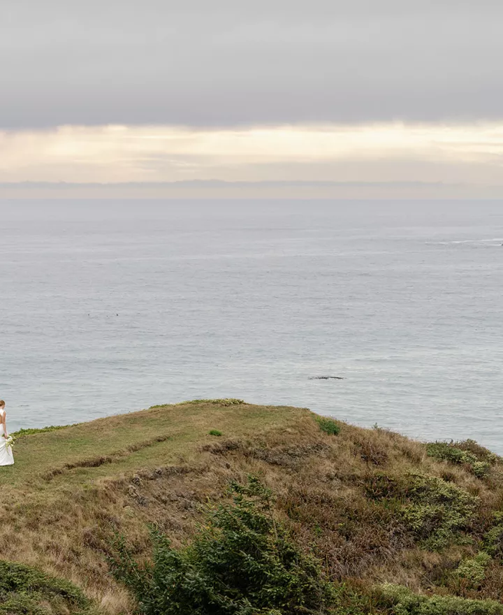 Model walks along the cliffs of Crook Point with the great expanse of water in the backdrop
