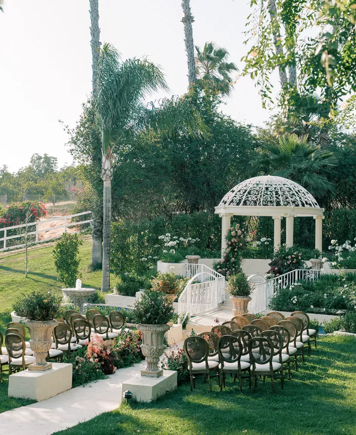 Sun-soaked outdoor imagined ceremony featuring deep moody floral palette and crisp white pergola at the center on the grounds of Villa Zosaneli