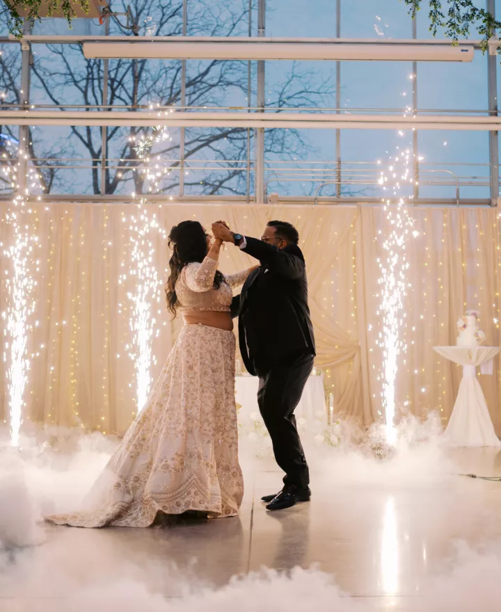 Bride and groom share their first dance accompanied by fog and cold sparks 
