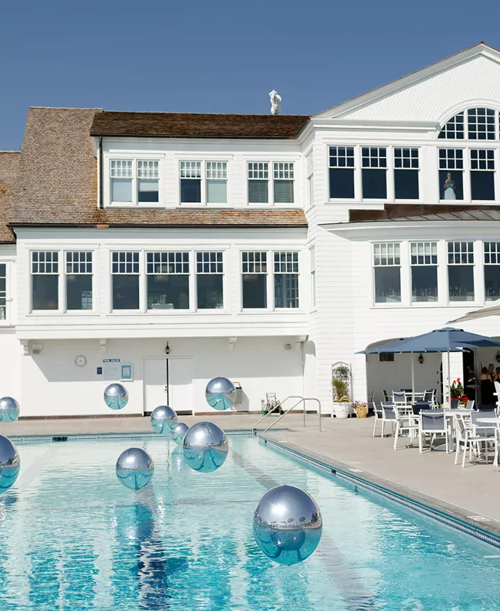 Sunny shot of reception at White Bear Yacht Club featuring pool and floating balloons