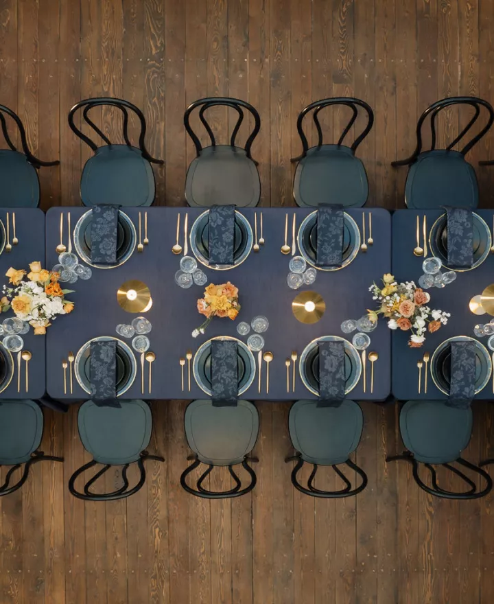 Bold tablescape featuring dark navy tones and metallic accents in one long table at Ellsworth Block