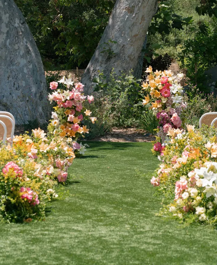 Outdoor ceremony set up featuring peachy florals on the grounds of Monserate Winery