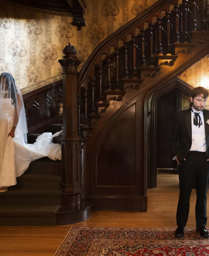 Bride descends staircase at Joslyn Castle to meet her groom in first look reveal